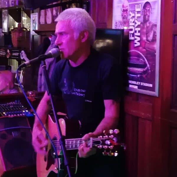 Musiker Phil Roberts spielt Gitarre bei einem Live-Auftritt in einer Bar.